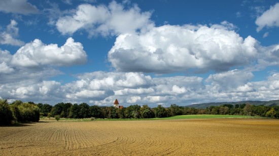 Das Symbolbild zeigt ein Dorf hinter einem Feld